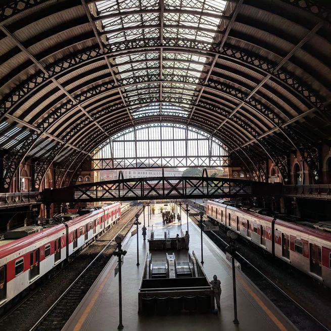 A column-generation based matheuristic for periodic and symmetric train timetabling with integrated passenger routing